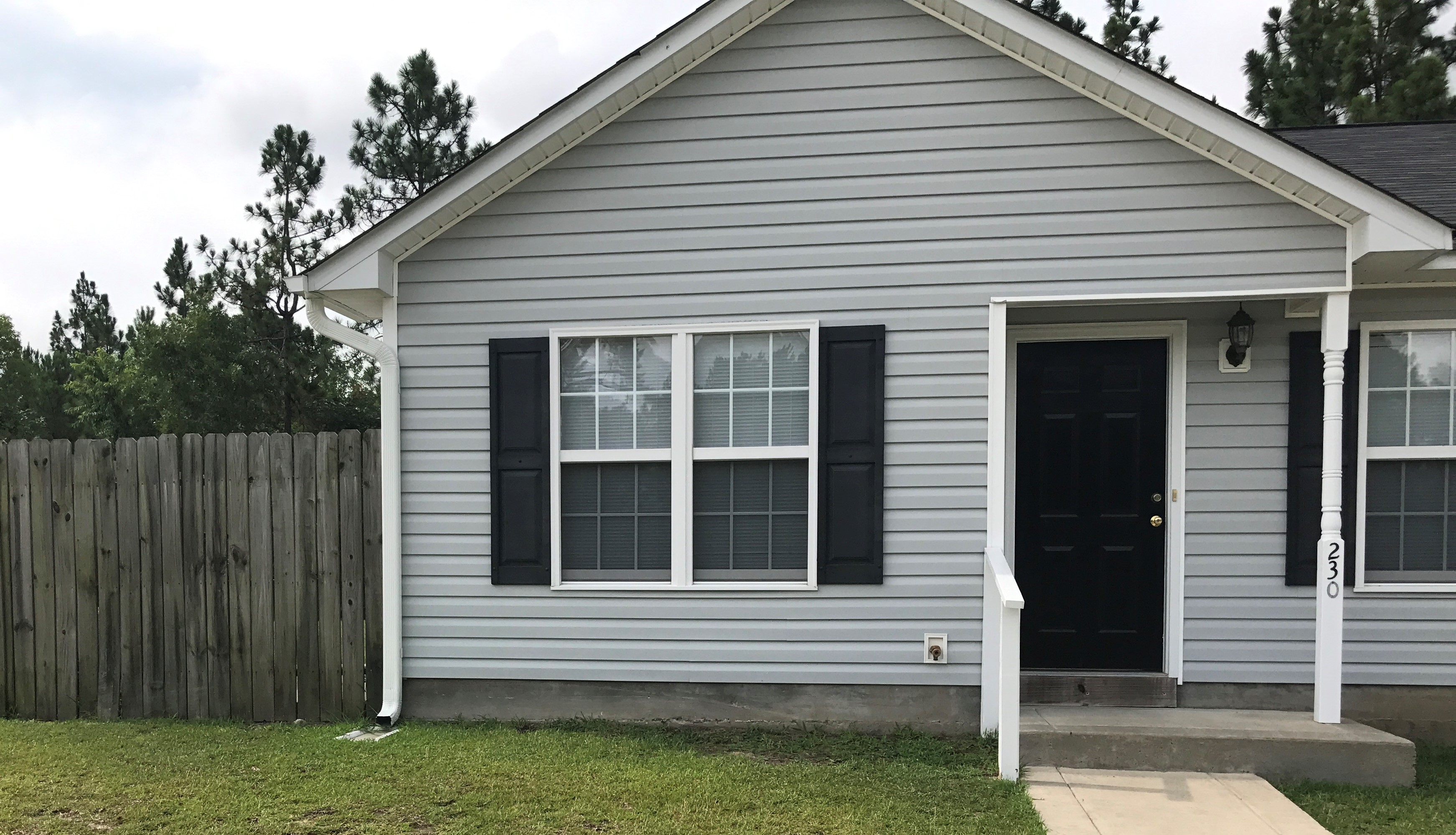 a white house with black shutters and a black door